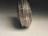 an old silver ring sitting on top of a white surface