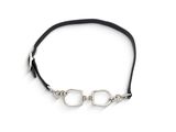 un gros plan sur un bracelet en cuir noir muni d'un fermoir en argent