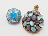two pieces of jewelry sitting on top of a table next to each other
