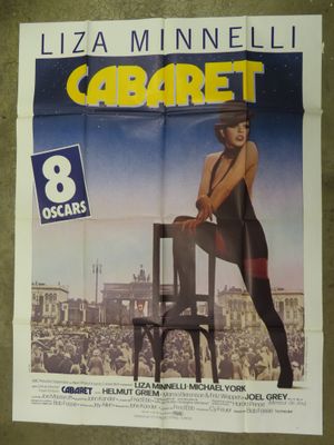 an image of a movie poster with a woman sitting on a chair in front of a crowd