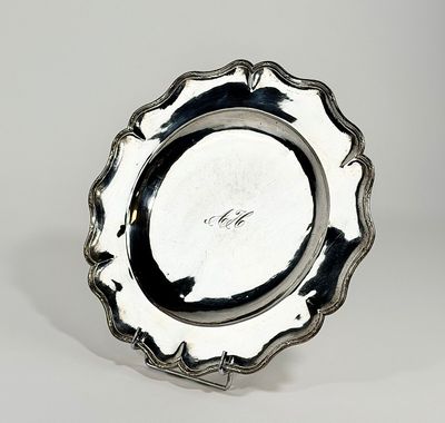 un plateau d'argent antique sur un support sur une surface blanche