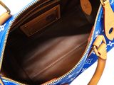 the inside of a blue louis vuitton handbag with gold handles