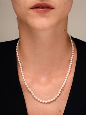 un gros plan d'une femme portant un collier de perles