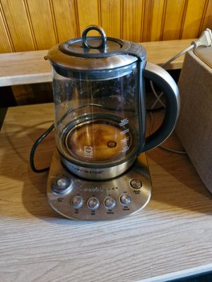 une cafetière posée sur un plan de travail, à côté d'un grille-pain et d'un autre grille-pain