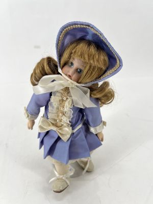 figurine en porcelaine représentant une petite fille vêtue d'une robe bleue et d'un bonnet