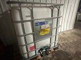 un grand conteneur blanc posé sur une palette dans un garage