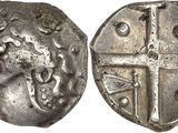 a silver coin with a cross on the front and a shield on the back