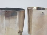 pair of silverplated vases on a white surface with a white background