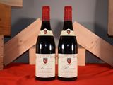deux bouteilles de vin rouge posées l'une à côté de l'autre sur une table