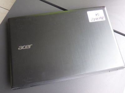 un ordinateur portable posé sur une table, sur lequel est collé un autocollant
