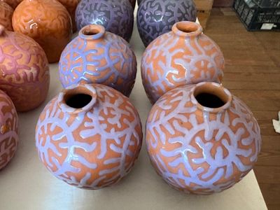 de nombreux vases de différentes couleurs posés sur une table