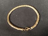 a close up of a gold bracelet on a black surface