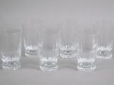 six verres sont alignés sur une surface blanche