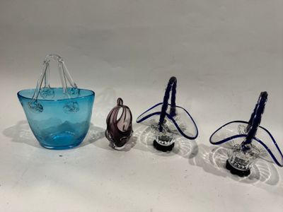 trois vases en verre bleu posés les uns à côté des autres sur une surface blanche