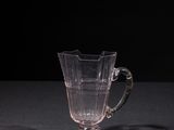 a glass cup sitting on a table with a black background
