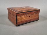 une vieille boîte en bois posée sur une surface grise