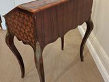 a small wooden table with a checkered top on it