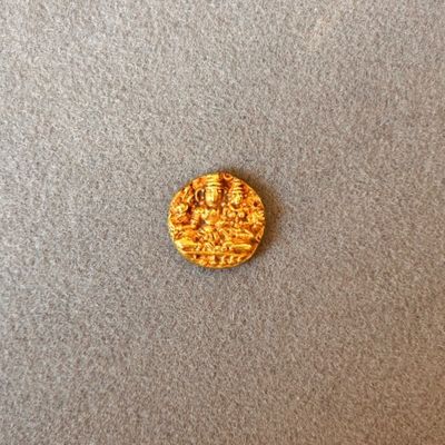 gros plan d'une pièce d'or sur une surface grise