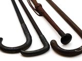 three old fashioned canes are lined up on a white surface
