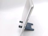 a laptop computer sitting on a stand on a white surface