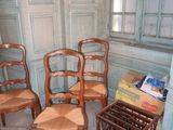 four wooden chairs in a room with blue walls