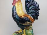 a figurine of a rooster on a green base