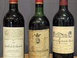 trois bouteilles de vin sont alignées sur une table en bois