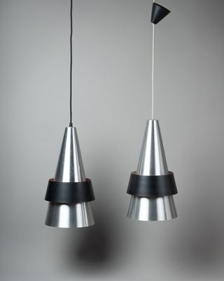 deux lampes en métal suspendues au plafond dans une pièce grise