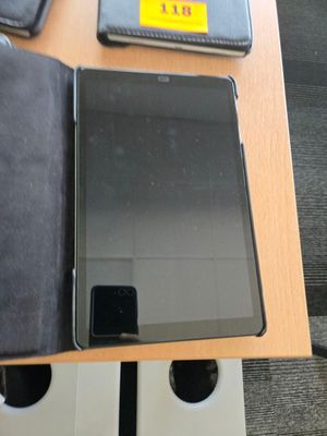 une tablette posée sur un bureau, à côté d'un portefeuille