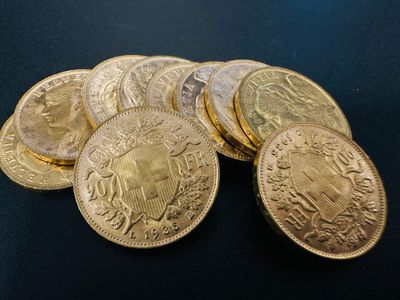a pile of gold coins sitting on top of a black surface