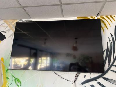 un téléviseur à écran plat fixé au mur d'une pièce
