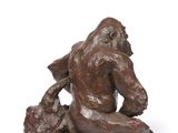 bronze sculpture of a man sitting on a rock with a dog