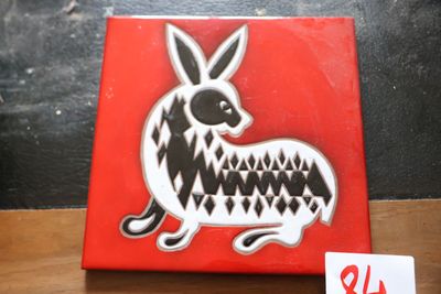 une boîte rouge sur laquelle figure une image en noir et blanc d'un lapin