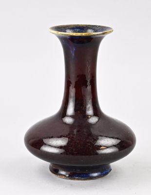 un vase marron avec un bord doré sur fond blanc