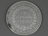 a close up of a coin on a table with a black background