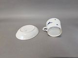 a small cup and saucer sitting on a table