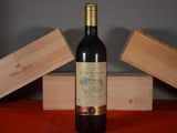 a bottle of wine sitting on a table next to two wooden boxes