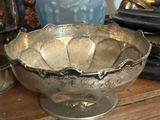 a silver bowl sitting on top of a wooden table