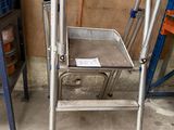 une échelle métallique sur laquelle est posé un plateau, dans un garage