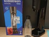 a soda streamer next to a soda dispenser on a table