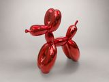 a red balloon dog sculpture sitting on top of a table