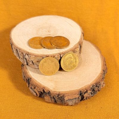two coins sitting on top of a piece of wood