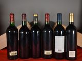 several bottles of wine are lined up on a red cloth