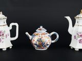 trois théières en porcelaine et une théière posées sur un fond noir