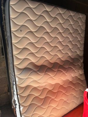 un matelas à l'arrière d'un camion, sur lequel est posé un sac rouge