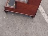 a wooden bench with a glass top sitting in the middle of a parking lot