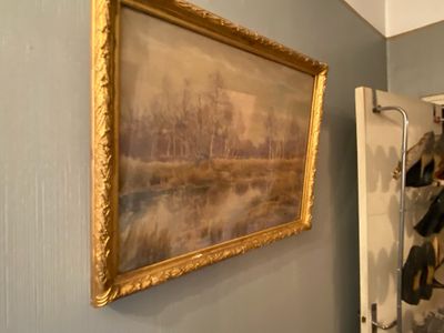 a painting hanging on the wall next to a mirror