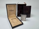 une boîte ouverte contenant une montre, posée sur une surface blanche
