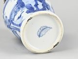 an antique blue and white vase with a feather on the lid