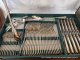 a green box with silverware in it on a table